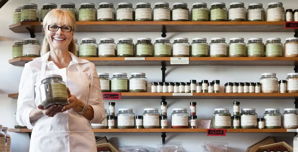 a person holding a jar of spices