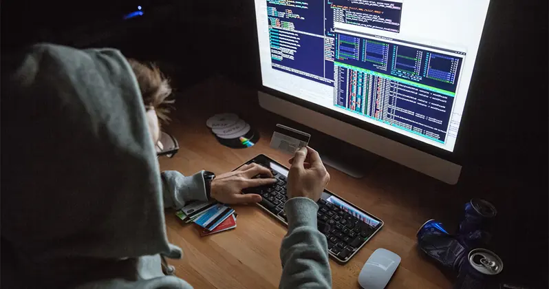 scammer holding credit card hacking