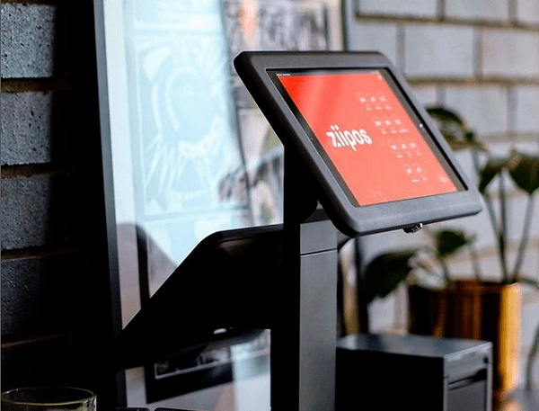 ZiiPOS Terminal on table with photo frame behind